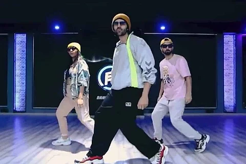 Kartik Aaryan is seen dancing along with two choregraphers.