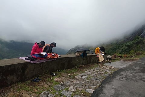 Students sit in the Eravikulam National Park to attend online classes