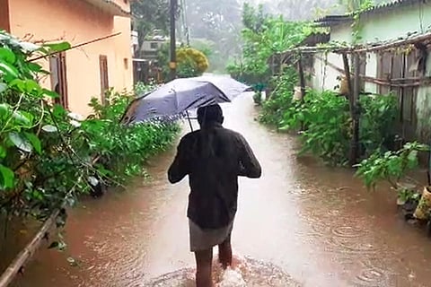 Man walking through flooded street in Kerala