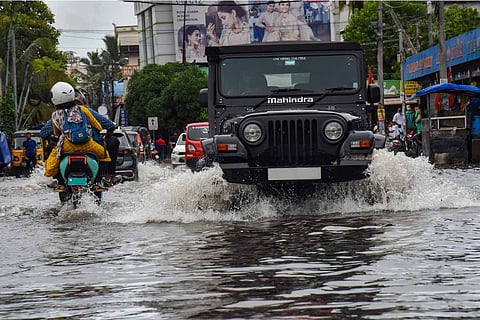 Vehicles wade through a waterlogged road after heavy rain in Kochi