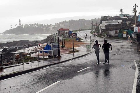 Youngsters run along the Vizhinjam coast amid rainfall, in Thiruvananthapuram: Monsoon arrives 3 days early in Kerala