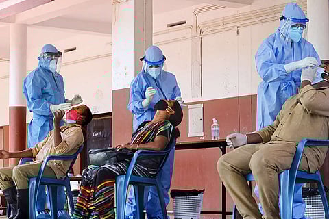 Frontline workers in PPE kits conducting tests for the coronavirus