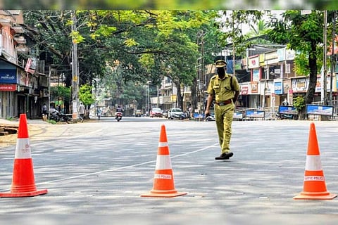 A deserted road during a COVID-19 induced lockdown on which only a policeman is walking
