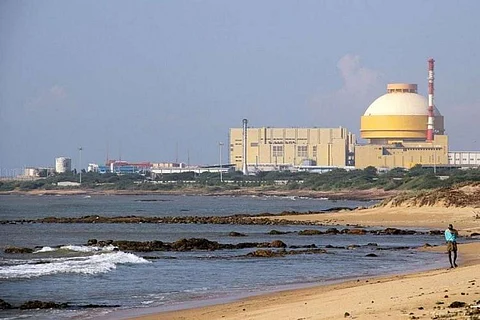 An elderly man seen walking on the coast as Kudankulam plant is seen in the background