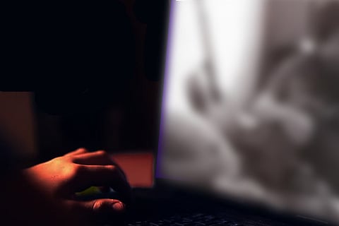 A person's hand over a laptop keyboard