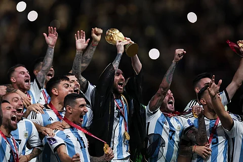Lionel Messi wearing bisht holds aloft World Cup trophy