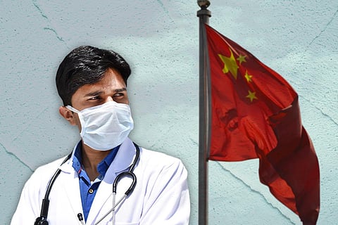 A man dressed in a white gown and a China flag in the background