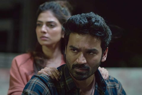 A scene from the film where Dhanush and Malavika are sitting on a bike