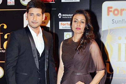 Mahesh babu in a black suit and Namrata in a dress with a drape