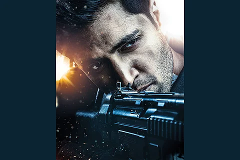 A close up shot of Adivi Sesh is seen holding a gun.