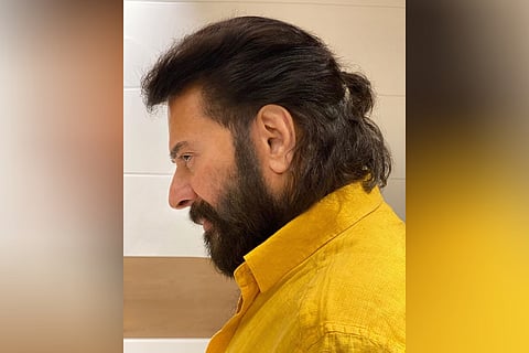 The actor is seen donning a bright yellow shirt, in a ponytailed hairdo