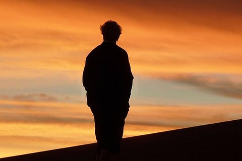 Silhouette of a man against an orange sky