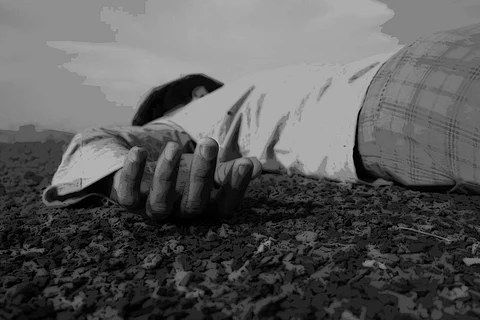 A representative image of a man lying down on the ground, a photo used to depict a dead body