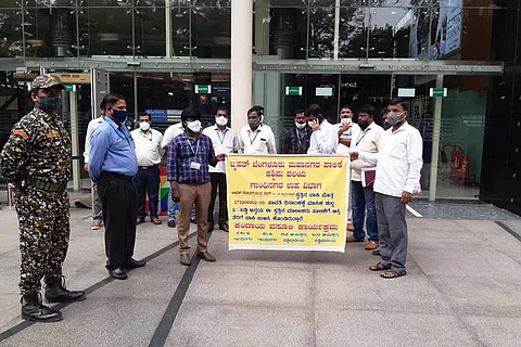 A group of people standing with a yellow coloured poster.