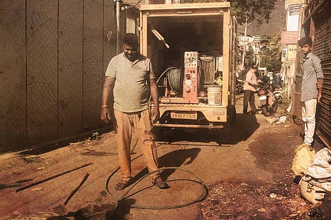 A sanitation worker cleaning a drainage