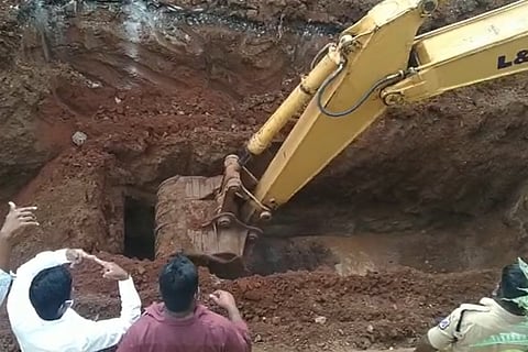 An earthmover digging up the manhole
