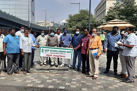 Revenue officials holding a closure sign in front of Manyata Tech Park