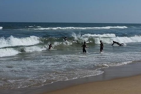 A file photo of children playing in the waves of Marina beach
