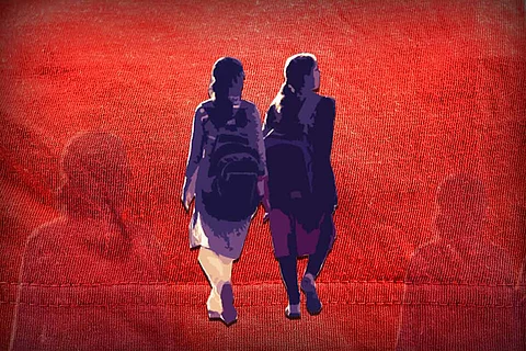 Two young school girls walking