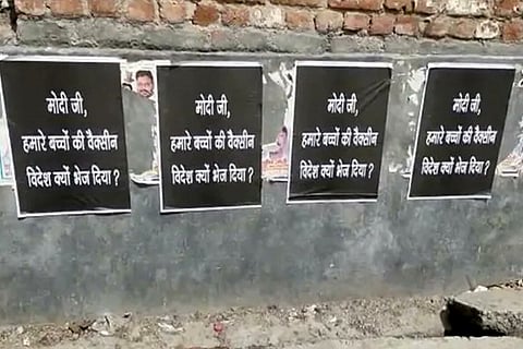 Posters on a wall in Delhi, asking Modi, "why vaccines for our children were sent abroad."