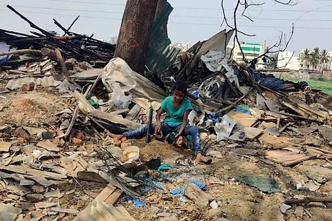 A small girl playing at the razed site while guarding their belongings