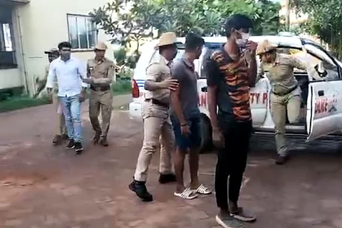The accused being brought in a police car by cops