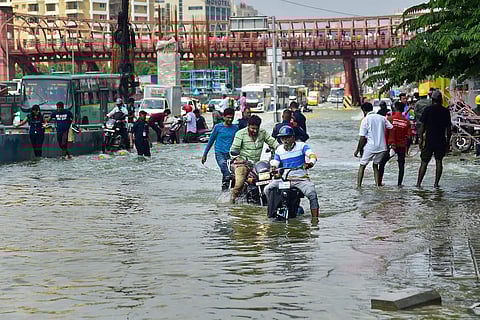 Motorists and pedestrians on a waterlogged road following monsoon rains in Bengaluru