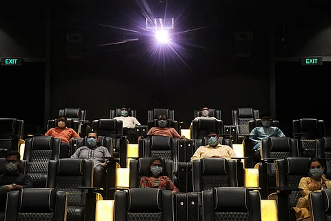 A photo taken inside the theatre with people wearing masks
