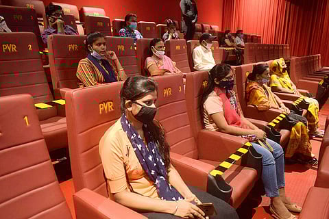Audience are seen with masks, following social distancing protocol in cinema halls.
