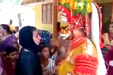 Muthappan Theyyam interacts with a Muslim woman