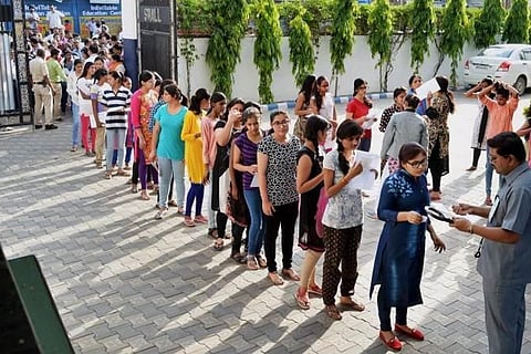 An officer scrutinises the certificates of NEET aspirants