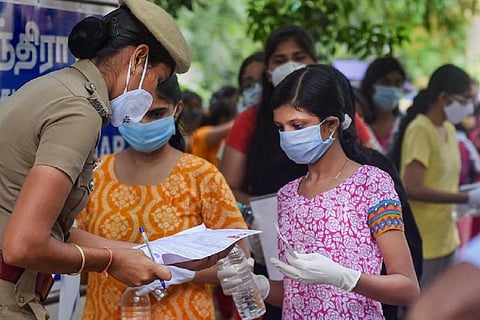 A policewoman checking hall ticket of NEET aspirants
