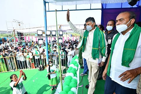 Chandrababu Naidu standing on a stage waving to protesters in Amaravati