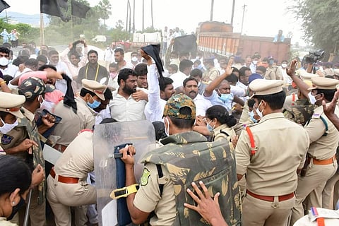 Police in uniform try to stall a clash between BJP and TRS workers in Telangana over the paddy procurement issue