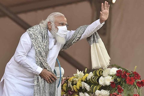 Prime Minister Narendra Modi waves at party activists during a public rally