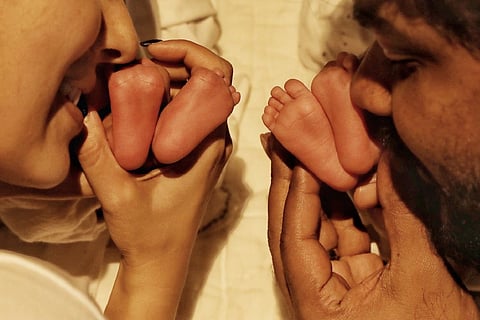 Nayanthara and Vignesh Shivan holding the feet of their twin boys