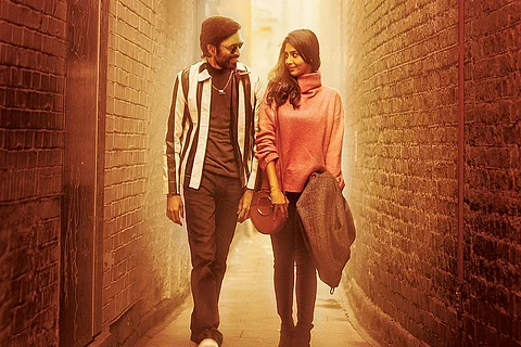 Dhanush and Aishwarya Lekshmi are seen taking a stroll in a narrow street in the image.