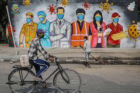 People in front of a mural of COVID warriors