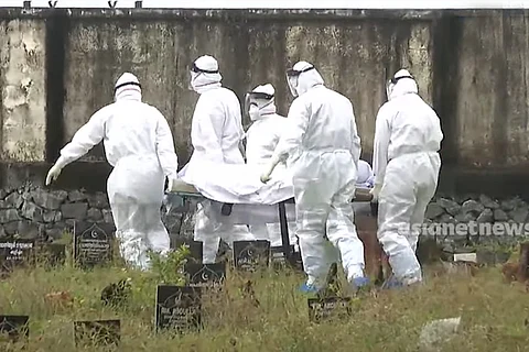 Body of a 12-year old boy died of Nipah in Kerala being taken to bury by health workers who all wear white PPE kits