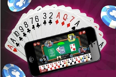 A physical deck of cards and online rummy on phone