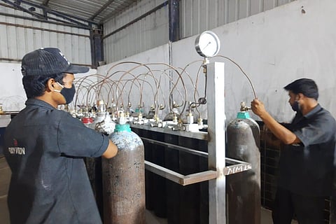 Two workers at an Oxygen refilling plant in Hyderabad.