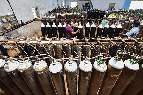 Workers refill cylinders with medical oxygen for COVID-19 patients, amid a surge in coronavirus cases