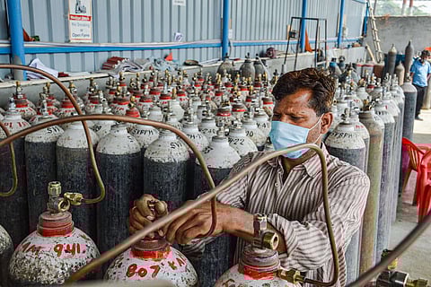 An employee refilling cylinders at an oxygen plant in Meerut