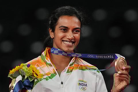 India's Pusarla V Sindhu poses for photographs while standing on the podium after receiving the bronze medal in women's singles badminton event at the Summer Olympics 2020, in Tokyo, Sunday, August 1, 2021