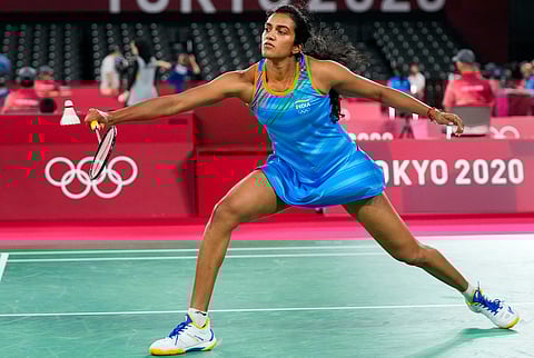 PV Sindhu wearing a blue outfit lunges for the shuttlecock during her match at the Tokyo Olympics