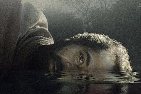 Paka movie poster showing a man with his head half submerged in water