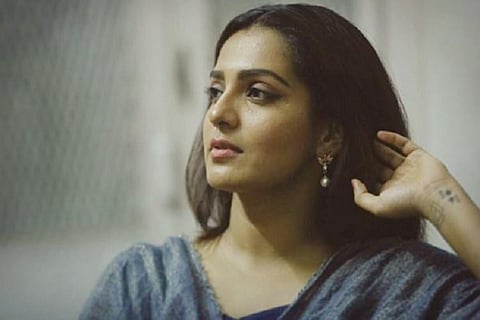 Parvathy is seen in a grey dress