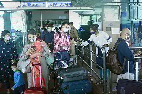 Several passengers standing in front a gate at airport