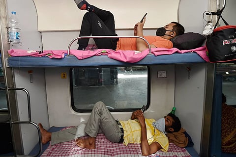 Passengers lie inside a coach of a special train following the resumption of passenger train services amid COVID pandemic in May 2020