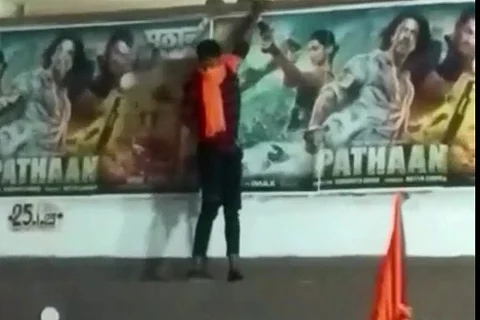 A Bajrang Dal activist tearing down the Pathaan poster in Hyderabad
